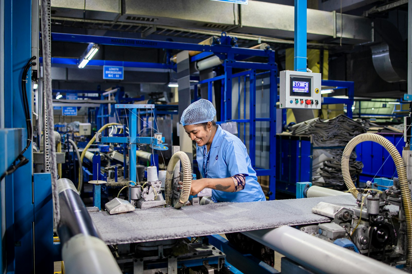 Textile factory operator working at production machinery